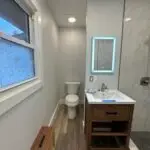 Picture of bathroom remodel includes new can light and lighted mirrors.