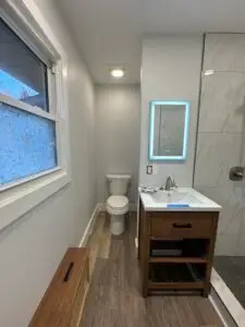 Picture of bathroom remodel includes new can light and lighted mirrors.
